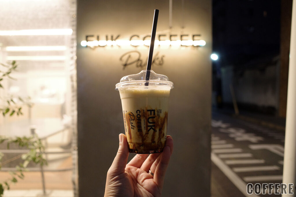 FUK COFFEE Parksのテイクアウトカップとお店ロゴライト